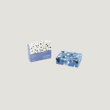 Lade das Bild in den Galerie-Viewer, Blaue Duftseife im Terrazzo-Look neben Verpackung mit Terrazzo-Design, handgemacht von Coudre Berlin.
Blue terrazzo-look scented soap next to packaging with terrazzo pattern, handmade by Coudre Berlin.